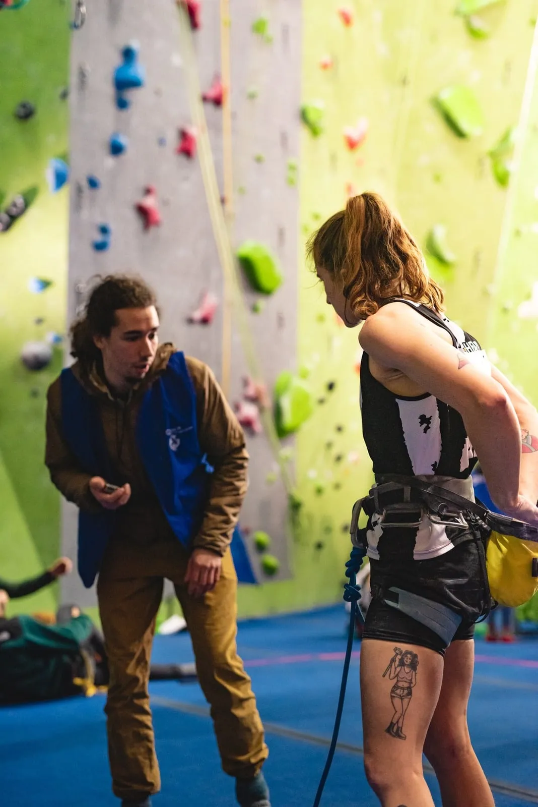 Route judge holding a timer next to a competitor at the base of the wall